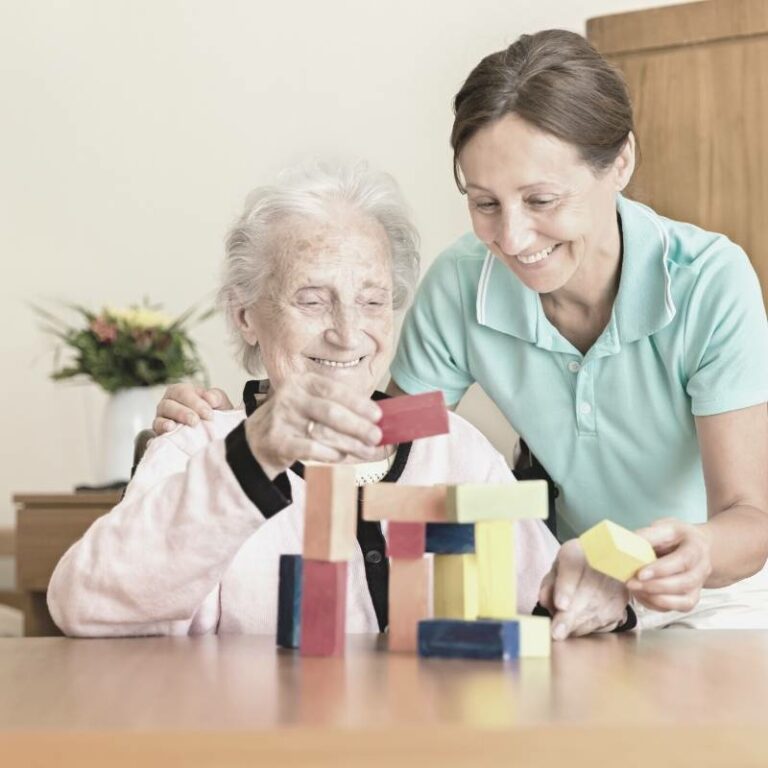 Cuidador jugando con una anciana